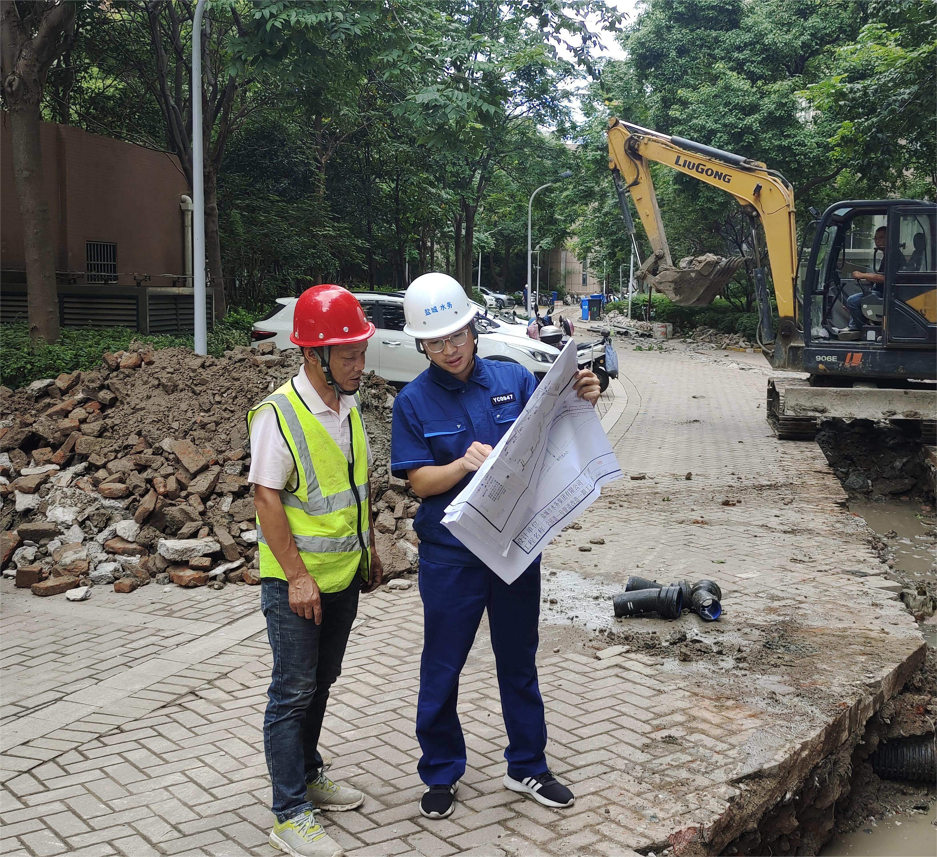 孟偉（右一）在公園道一號(hào)小區(qū)組織施工方按圖施工.jpg